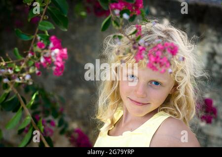 belle fille blonde et fleurs roses Banque D'Images