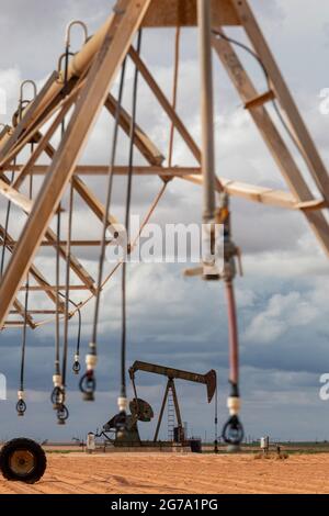 Plains, Texas - un puits de pétrole près de l'équipement d'irrigation sur les terres agricoles du bassin Permien. Banque D'Images