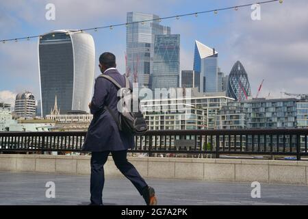 Londres, Royaume-Uni. 12 juillet 2021. Un homme passe devant les gratte-ciel de Londres sur le sentier de la Tamise du London Bridge. Crédit : SOPA Images Limited/Alamy Live News Banque D'Images