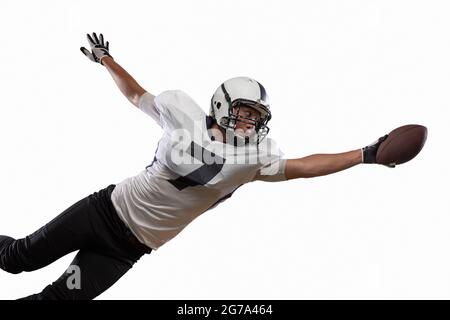 Portrait d'un joueur américain de football qui attrape le ballon en saut isolé sur fond blanc de studio. Banque D'Images