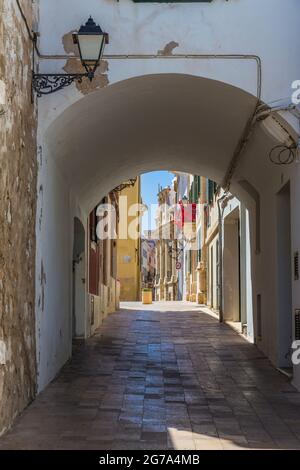 Ruelle étroite avec arche, balcon décoré de rouge à l'arrière, CAN Mercadal, bibliothèque de la ville, Biblioteca Central insular, Placa de la Conquesta, Mahon, Mao, Minorque, Espagne,Europe Banque D'Images