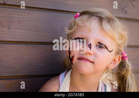 jolie petite fille blonde avec peinture de visage Banque D'Images