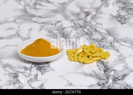 Curcuma moulu qui est utilisé pour l'aromatisant et sous forme de capsule à prendre comme supplément de santé. Banque D'Images