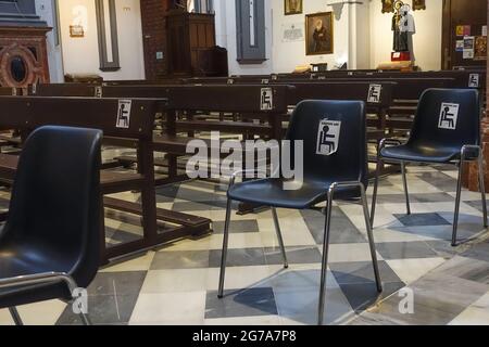 Chaises dans l'église, distanciation sociale, restrictions de covid, les sièges doivent rester vides afin de garder la distance, Malaga, Espagne. Banque D'Images