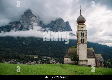 Église Saint-Valentin, Seis am Schlern, Italie. Schlern montagne avec des nuages pluvieux en arrière-plan Banque D'Images