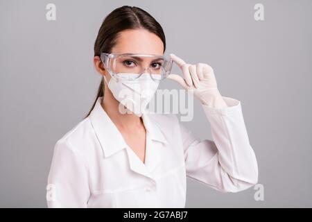 Photo portrait femme médecin portant un masque de protection lunettes gants prêt à travailler isolé fond gris Banque D'Images