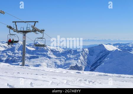 Géorgie, Gudauri, 8 mars 2013 : le soutien du télésiège et des skieurs. Sur fond de neige et de ciel bleu. Le concept de wi actif Banque D'Images