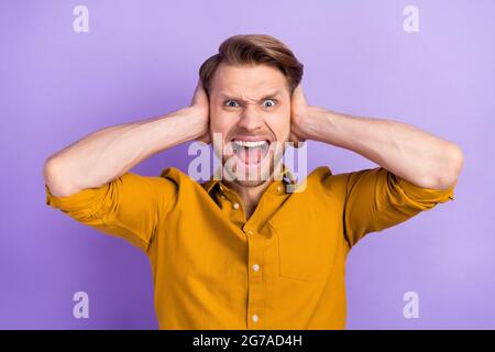 Portrait de l'attrayant fou outragé fureur gars fermeture oreilles hurler isolé sur fond violet couleur violet couleur Banque D'Images