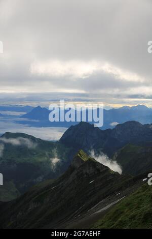 Scène au lever du soleil vue depuis le mont Brienzer Rothorn. Vue sur Stanserhorn et Lucerne. Brouillard se levant lentement après une nuit de pluie. Banque D'Images