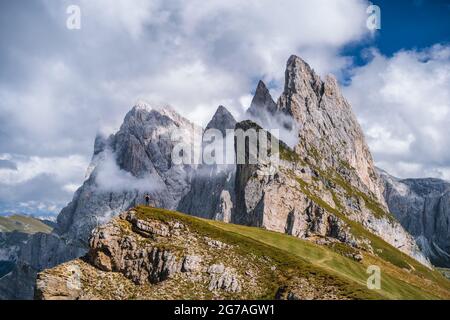 Un homme en face des pics épiques de Furchetta et de Sass Rigais à Seceda, Alpes Dolomites, chaîne de montagnes Odle, Tyrol du Sud, Italie, Europe. Concept de vacances de voyage Banque D'Images