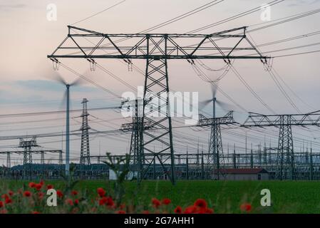 Allemagne, Saxe-Anhalt, Wolmirstedt, pylônes d'électricité et éoliennes à la sous-station Wolmirstedt. Banque D'Images