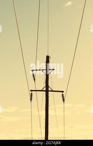 Photographie d'un poste téléphonique en bois et de câbles contre un ciel bleu Banque D'Images