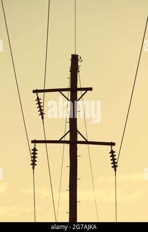 Photographie d'un poste téléphonique en bois et de câbles contre un ciel bleu Banque D'Images