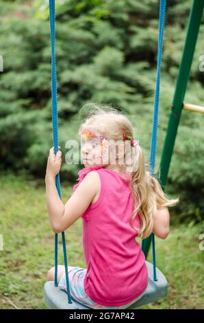 un petit enfant s'amusait à se balancer dans le parc Banque D'Images