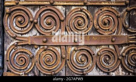 Ferrures de portes en forme de spirale sur le portail roman de l'église Saint Martin à Palalda près d'Amélie les bains.L'église a été construite au XIIe siècle. Banque D'Images