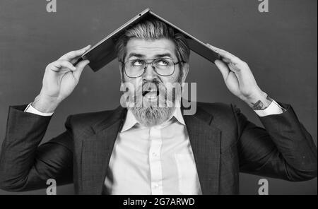 Beaucoup d'informations. Folie en ligne. Fournir des informations à jour précises. Un professeur tient un ordinateur portable pour surfer sur Internet. Ordinateur portable barbu sur la tête Banque D'Images