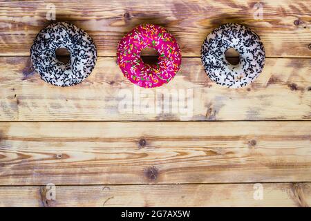 Beignets sur fond en bois. Les aliments sucrés reposent à plat avec un espace pour les copies. Image de maquette de nourriture. Photo de haute qualité Banque D'Images