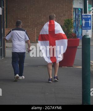 Un fan de football d'Angleterre est perçu comme drapé dans un drapeau d'Angleterre Banque D'Images