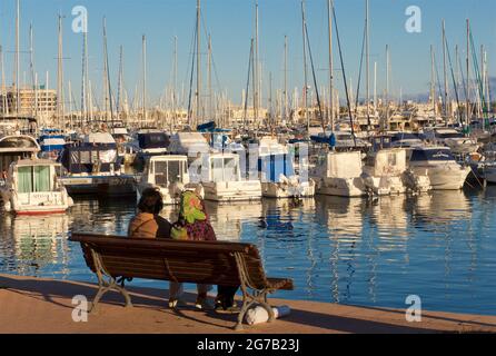 Bateaux et bateaux de plaisance d'Alicante. Deux femmes assises sur un banc donnant sur la marina. Alicante, Espagne Banque D'Images