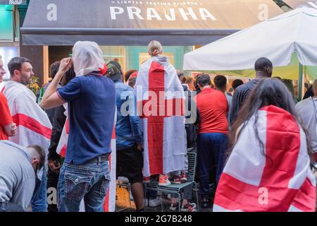 Les fans de football enveloppent les drapeaux de l'Angleterre en regardant le match de 2020 euros entre l'Angleterre et l'Italie lors de la finale du championnat d'Europe 2020 Londres Banque D'Images
