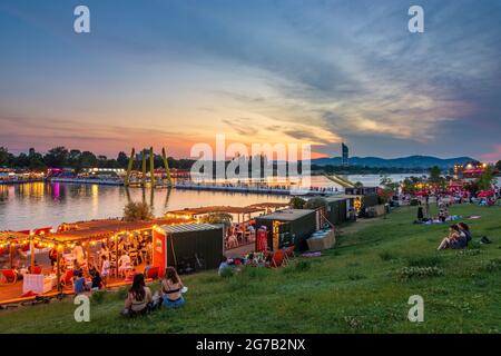 Vienne, zone de loisirs Plage de Copa au fleuve Neue Donau (Nouveau Danube), gens sur la prairie, bar, vue sur Wienerwald et Tour du millénaire en 22. Donaustadt, Wien, Autriche Banque D'Images