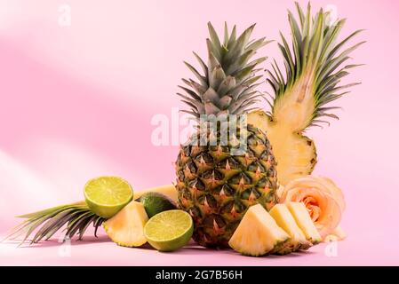 Ananas frais mûr et tranches de fruits coupées sur fond rose. Promotion Hello, Summer ou Summer Season. Banque D'Images