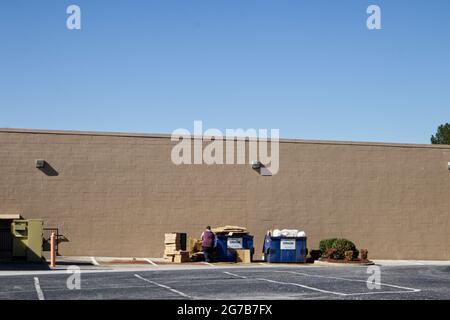 Augusta, GA USA - 03 04 21: Personne pliant le carton et mettant dans une benne à ordures Banque D'Images