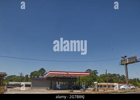 Augusta, GA USA - 04 22 21: Station-service urbaine et voitures garées et bâtiments d'époque en arrière-plan Banque D'Images