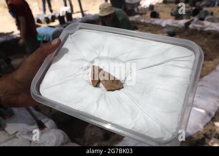 Kiryat Gat, Israël. 12 juillet 2021. Un archéologue israélien montre un fragment d'une carafe d'argile de 3,100 ans avec une inscription biblique sur le site archéologique Khirbet ar-Ra'i près de Kiryat Gat, dans le sud d'Israël, le 12 juillet 2021. Les archéologues israéliens et australiens ont découvert une carafe en poterie avec une inscription biblique rare dans le sud d'Israël, qui date d'il y a 3,100 ans, a déclaré l'Autorité des Antiquités d'Israël (IAA) lundi. Credit: Gil Cohen Magen/Xinhua/Alay Live News Banque D'Images