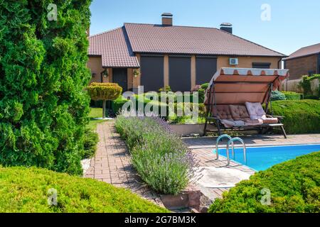 Villa de style européen avec piscine et jardin avec des buissons joliment taillés Banque D'Images