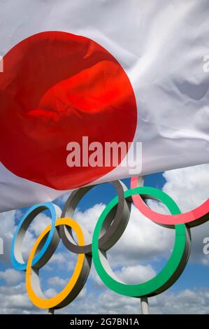 RIO DE JANEIRO - MARS 2016 : un drapeau japonais flotte dans le vent devant les anneaux olympiques debout sous un ciel bleu vif. Banque D'Images