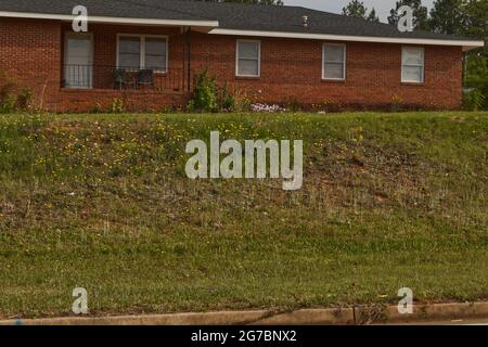 Augusta, GA USA - 04 29 21: Aménagement paysager urbain guirlande fleurs maison en briques Banque D'Images