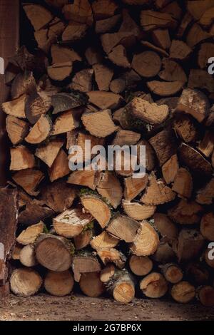 Bûches d'arbre hachées empilées dans une pile de bois en bois Banque D'Images