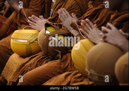 beaucoup de moines pressent leurs mains ensemble pour prier avant que les gens donnent l'aumône au moine Banque D'Images