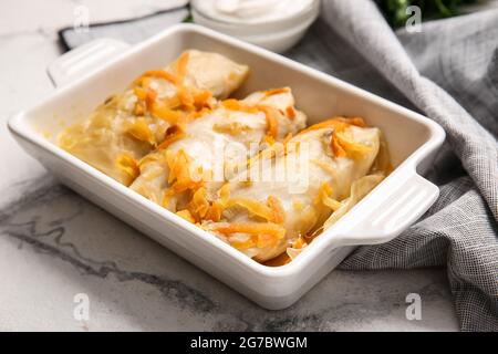 Plat de cuisson avec de savoureux petits pains de chou farcis sur fond clair Banque D'Images