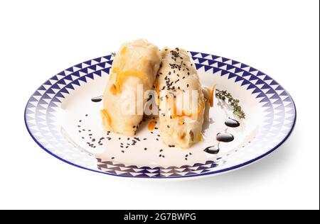 Assiette de délicieux petits pains de chou farcis sur fond blanc Banque D'Images