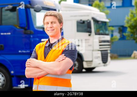 Logistique - fier conducteur ou le transitaire à l'avant des camions et remorques, sur un point de transbordement Banque D'Images