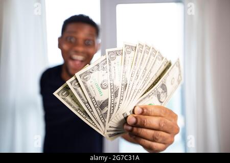 Afro man détient une certaine devise US d'un dollar, l'accent sélectif sur la main avec l'argent. Banque D'Images