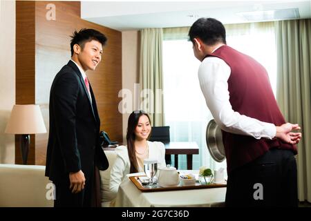 Service en chambre Chinoise Asiatique ou serveur, vous pourrez gérer les aliments dans une chambre d'hôtel de luxe ou grand Banque D'Images