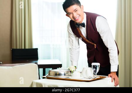 Service en chambre Chinoise Asiatique ou serveur, vous pourrez gérer les aliments dans une chambre d'hôtel de luxe ou grand Banque D'Images