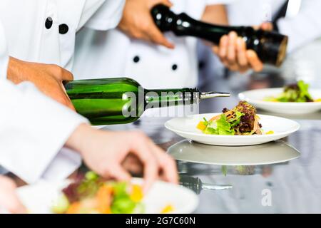 Chef de l'Indonésie en Asie avec d'autres cuisiniers dans un restaurant ou un hôtel restaurant la cuisine, plaque ou plat de finition Banque D'Images