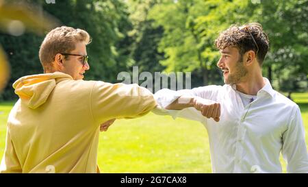 Oldenburg, Allemagne. 03ème juillet 2021. ILLUSTRATION - deux hommes se saluent les uns les autres avec leurs coudes. (Scène posée) Credit: Mohssen Assanimoghaddam/dpa/Alay Live News Banque D'Images