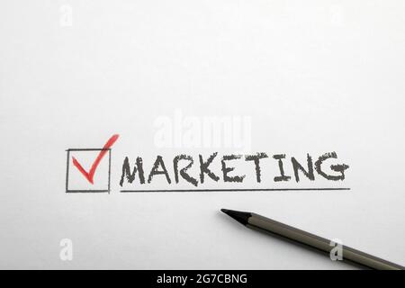 Cochez le mot marketing. Crayon sur une feuille blanche. Banque D'Images