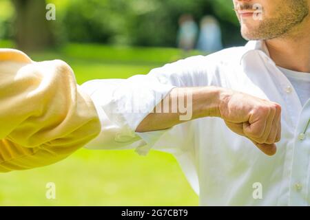 Oldenburg, Allemagne. 03ème juillet 2021. ILLUSTRATION - deux hommes se saluent les uns les autres avec leurs coudes. (Scène posée) Credit: Mohssen Assanimoghaddam/dpa/Alay Live News Banque D'Images