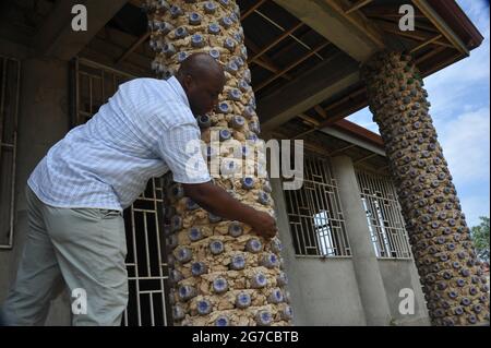 Accra, Ghana. 24 juin 2021. Martial Zohoungbogbo montre des bouteilles en plastique recyclées remplies de terre, qui sont utilisées comme briques pour construire une bibliothèque communautaire, à Accra, Ghana, le 24 juin 2021. Martial Zohoungbogbo, un architecte qui détient une double citoyenneté du Ghana et du Bénin, a construit une bibliothèque communautaire avec 45,000 bouteilles en plastique recyclées à la périphérie d'Accra. POUR ALLER AVEC "Feature: L'architecte africain construit une bibliothèque communautaire avec 45,000 bouteilles en plastique recyclé" crédit: Seth/Xinhua/Alamy Live News Banque D'Images