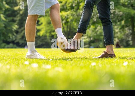 Oldenburg, Allemagne. 03ème juillet 2021. ILLUSTRATION - deux hommes se saluent les uns les autres avec leurs pieds. (Scène posée) Credit: Mohssen Assanimoghaddam/dpa/Alay Live News Banque D'Images