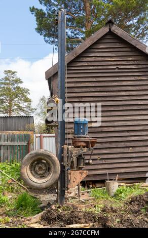 engin de forage de petite taille. forage de puits d'eau sur un terrain de jardin ou une maison privée. Banque D'Images