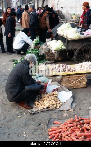 Kunden und Verkäufer auf einem Lebensmittelmarkt in der Stadt Xian, Chine 1998. Clients et vendeurs sur un marché dans la ville de Xian, Chine 1998. Banque D'Images