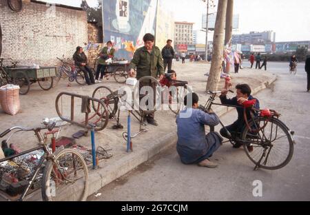 Schnelle Fahrradreparatur auf der Straße in der Stadt Xian, Chine 1998. Réparation de bicyclettes dans les rues de la ville de Xian, Chine 1998. Banque D'Images