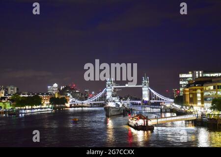 Vue de nuit sur la Tamise avec le pont illuminé de Londres et le HMS Belfast. Banque D'Images